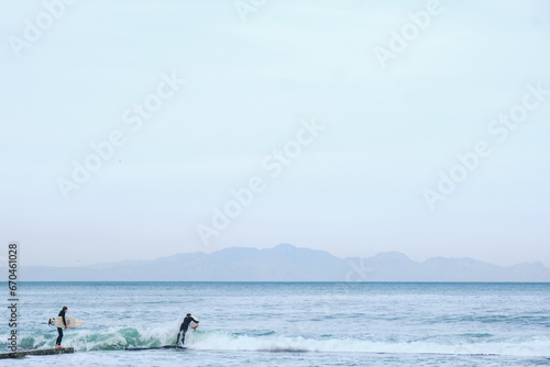 Surfer enters ocean for a surf session.