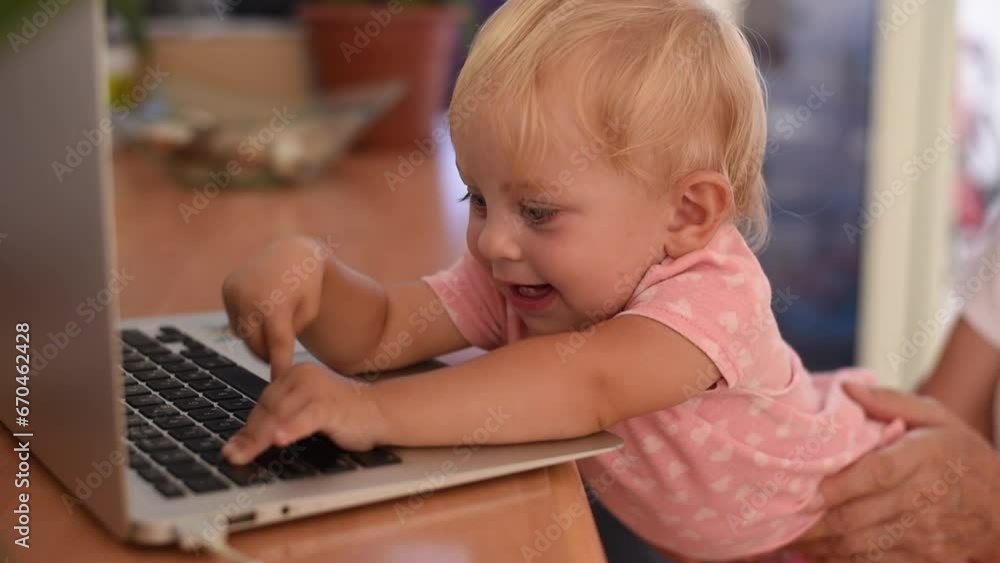 Little happy baby smile and typing on keyboard of laptop. Small hand fingers touch black buttons. Baby learning new world. play on laptop. Little happy baby smile and typing on keyboard of laptop. Small hand fingers touch black buttons. Baby learning new world. play on laptop.