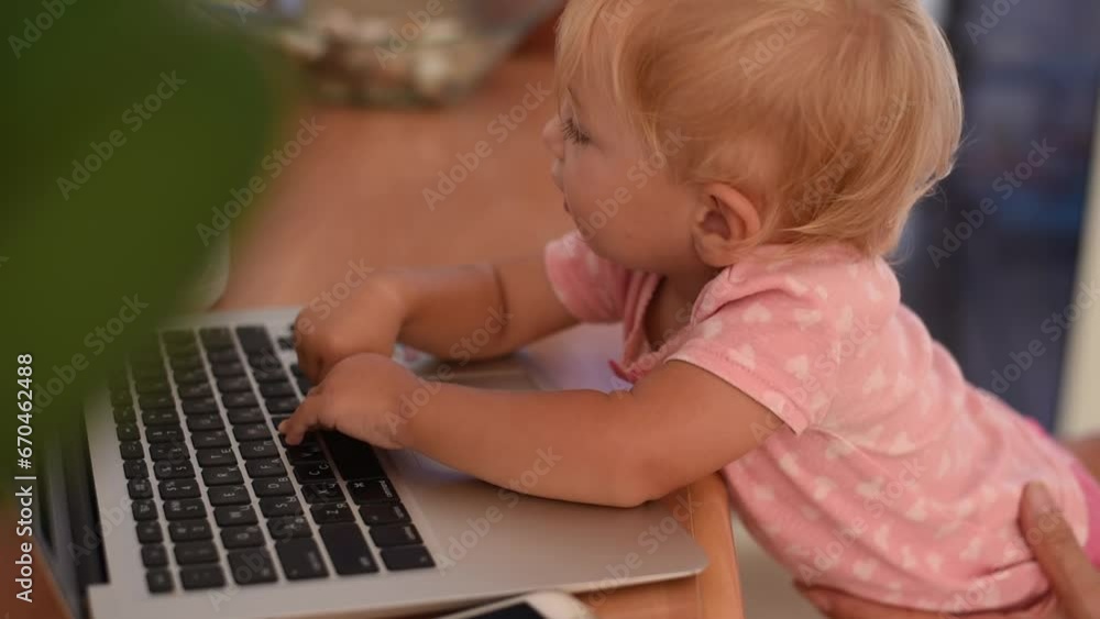 Little happy baby smile and typing on keyboard of laptop. Small hand fingers touch black buttons. Baby learning new world. play on laptop.