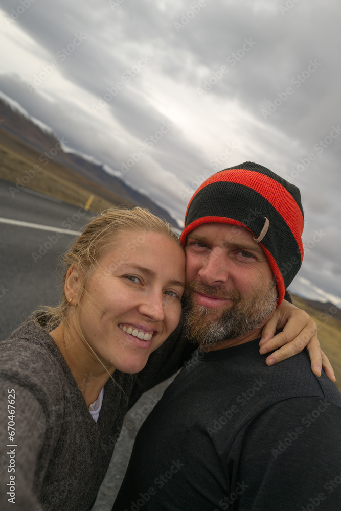 Couple selfie smiling overlooking mountains in Iceland