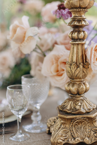 Decor of festive wedding table in classic style, bronze cast vintage candlestic, antique crystal .