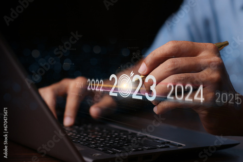 Fototapeta Naklejka Na Ścianę i Meble -  Trend of 2024. people business investor using laptop with virtual 2024 year diagram, business trend, change from 2023 to 2024, strategy, investment, business planning and happy new year concept