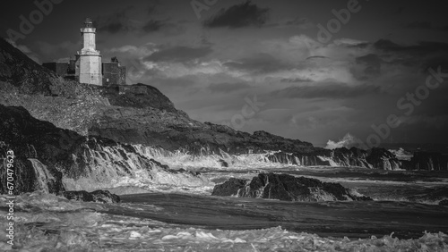 Experience the timeless drama of nature in this striking black and white photograph capturing Mumbles Lighthouse amidst a fierce storm. Waves crash against the rocks, leaving behind a trail of white f