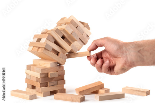 Businessman removing wooden block from falling tower on table.