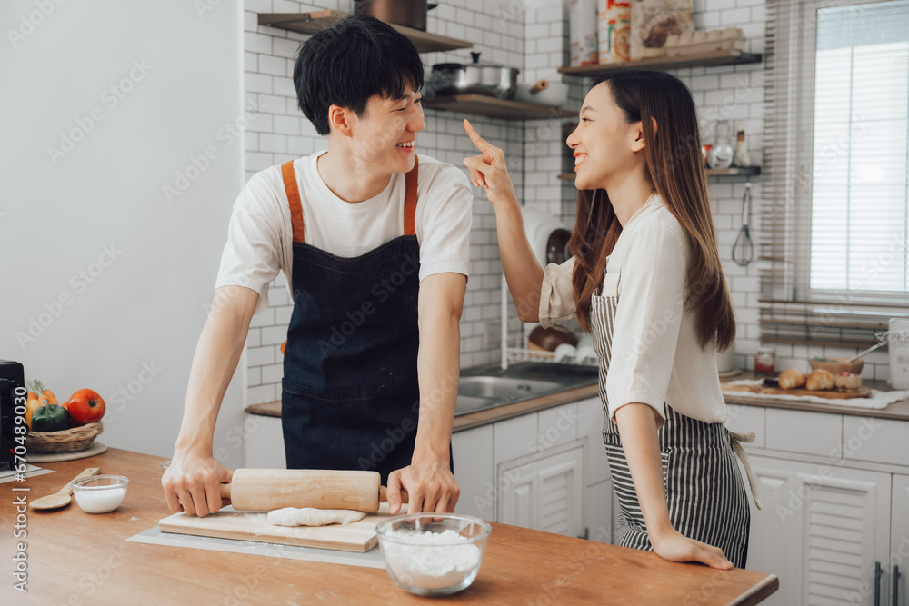Couple cooking together in their kitchen at home Couple cooking together in their kitchen at home