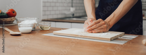 Asian couple standing in kitchen at home preparing together yummy dinner on first dating, spouses chatting enjoy warm conversation and cooking.