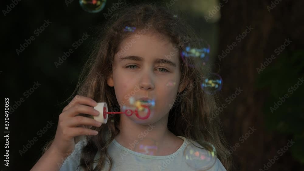 Little Girl Blowing Soap Bubbles Having Fun Playing Outside, Child Innocence and Curiosity. Girl Kid Blowing Soap Bubbles in Park, Garden and Nature, Having Fun, Joy Childhood Development, Freedom.