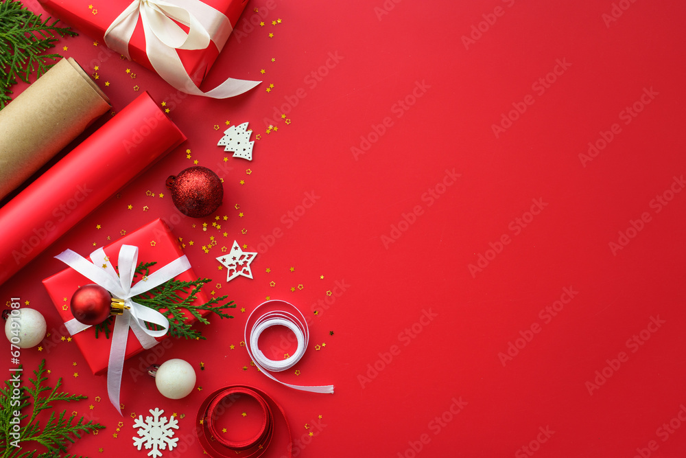 Christmas Present box and decorations at red background. Wrapping christmas present. Flat lay image.