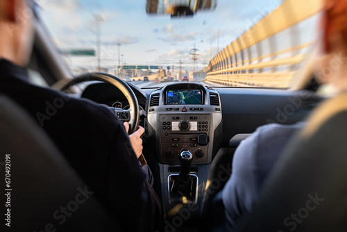 Motion zoom Motorway. Ring bypass road. Blurry view of the road through the windshield of the car. The car control panel, the navigator is turned on. The driver and passenger are looking at the road photo