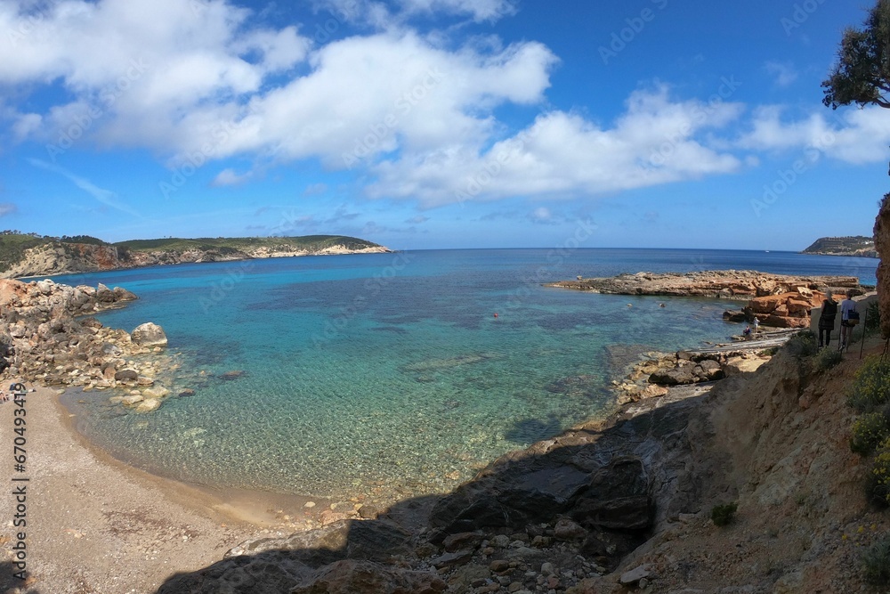 Scenic view of a beach in Ibiza, with a sandy shoreline, blue sky, and turquoise waters