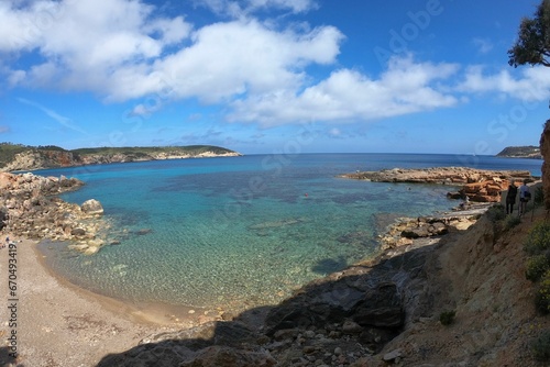 Scenic view of a beach in Ibiza, with a sandy shoreline, blue sky, and turquoise waters