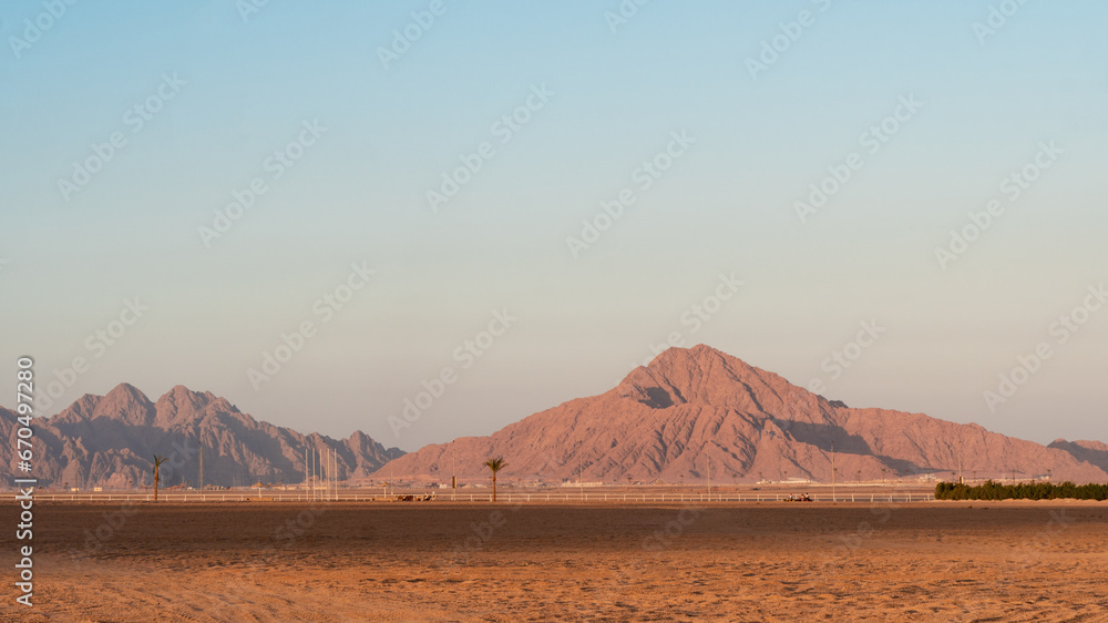 Panoramic view on sand, mountains hills in South Sinai desert, Egypt. Orange sand and haze. Panoramic view on sand, mountains hills in South Sinai desert, Egypt. Orange sand and haze.
