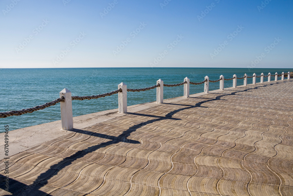 Sea fences with ropes. Fences along the shore. Barriers near the sea. Concrete posts with rope. Posts with ropes.