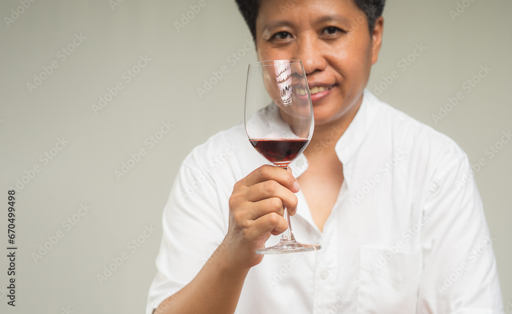 Young woman tomboyish wearing a white, short-sleeve with a mandarin collar and holding a glass of wine Young woman tomboyish wearing a white, short-sleeve with a mandarin collar and holding a glass of wine