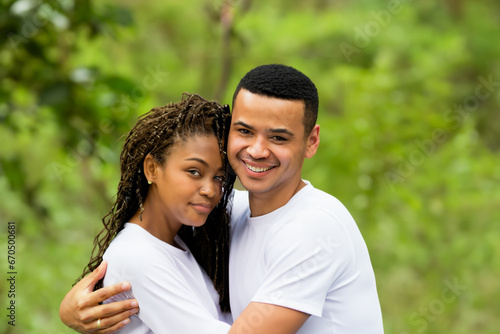 happy couple in nature. a young couple, a guy and a girl, stand in the forest in white T-shirts and hug