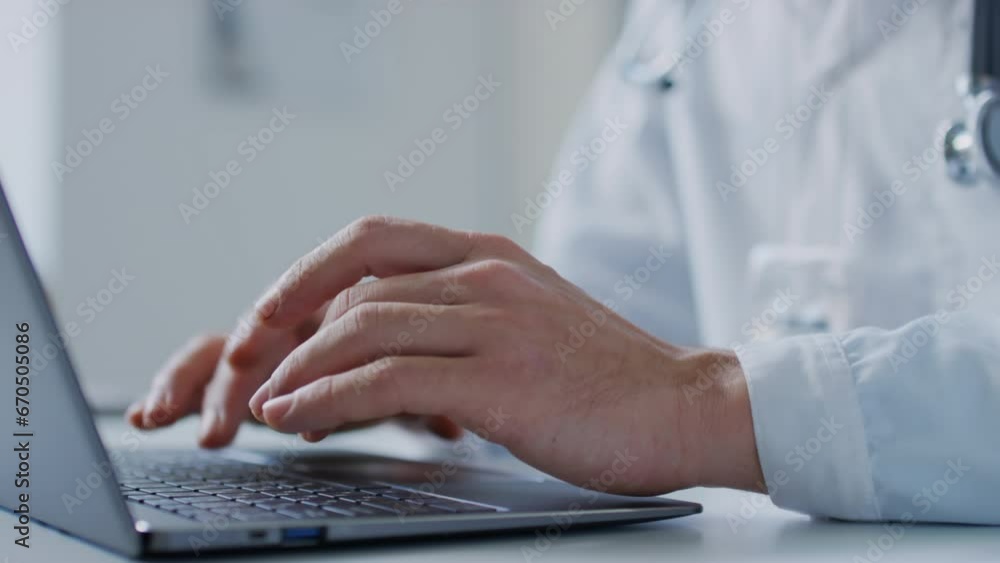 Pan closeup of hands of unrecognizable doctor typing on laptop in hospital Pan closeup of hands of unrecognizable doctor typing on laptop in hospital