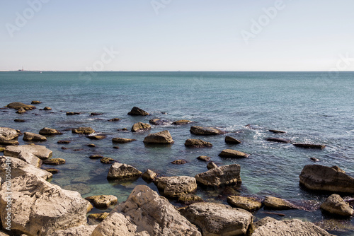 Rocky shore of the Caspian Sea. Large stones on the seashore. A heavenly place. Embankment of the Caspian Sea in the city of Aktau.