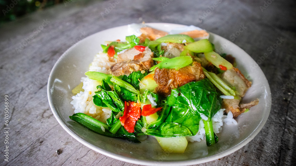 Thai food, kana moo krob.(fried kale mixed crispy pork),Crispy Pork fried with Kale Thai delicious food, closeup, side view Thai food, kana moo krob.(fried kale mixed crispy pork),Crispy Pork fried with Kale Thai delicious food, closeup, side view