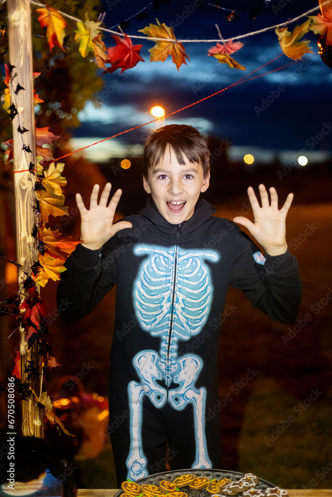 Children, celebrating Halloween outdoors at night, dracula, vampire, mumie, pumpkins