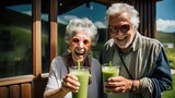 A retired couple drinks and enjoys a healthy green vegetable smoothie made from organic greens in the background of their home, Vegetarian detox diet for health