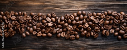Coffee beans spread on a rustic wooden table © Georgina Burrows