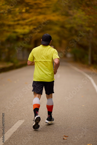 Portrait of a middle-aged man running in the park on an autumn day.