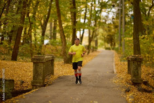 Portrait of a middle-aged man running in the park on an autumn day. © czamfir