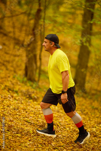 Portrait of a middle-aged man running in the park on an autumn day.