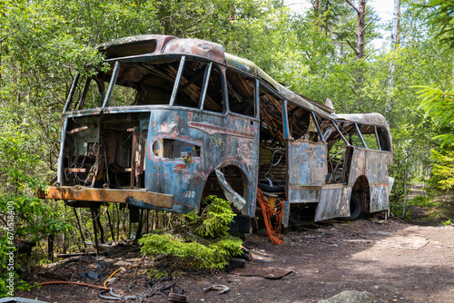 Dark tourism, forgotten bus wreckage in a forest photo