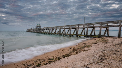 View of the wooden pier in Luc-sur-Mer, France, in the evening 