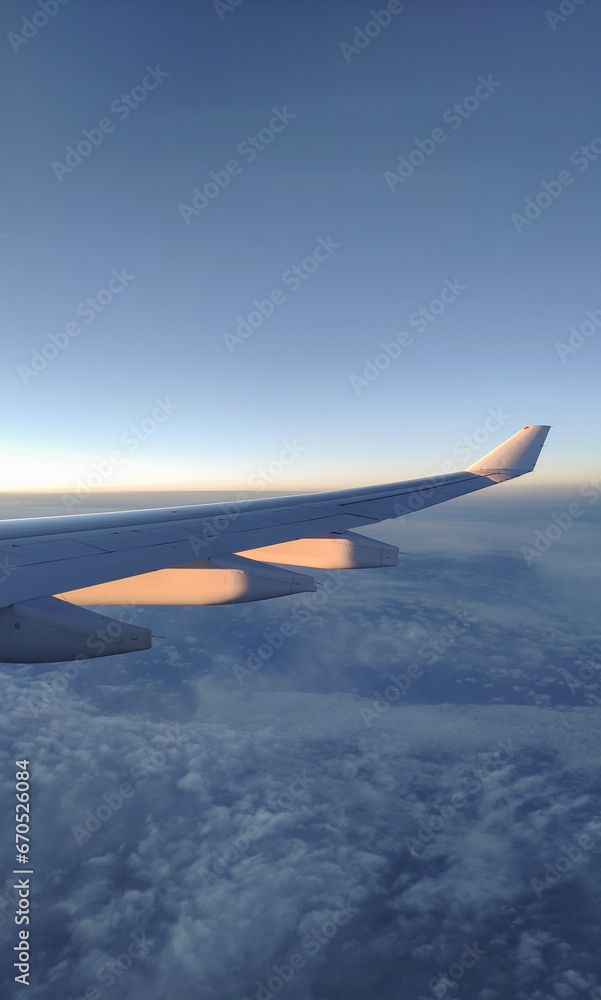 Obraz premium fly and travel, view from the window of an airplane on the wing during sunset