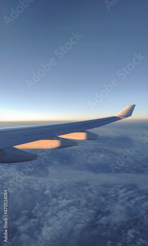 fly and travel, view from the window of an airplane on the wing during sunset