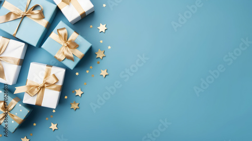 Christmas gift and golden ribbon, ball, decoration and snowflake group on a blue surface. Flat lay, top view, copyspace. © linda_vostrovska