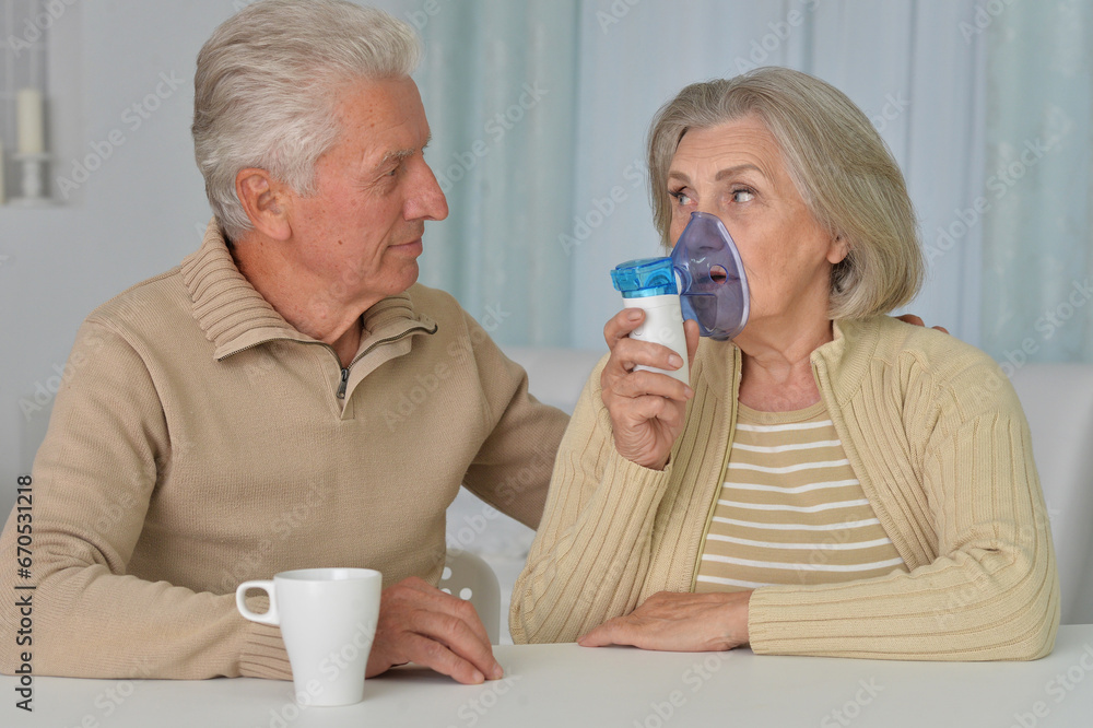 Portrait of sick senior woman with inhaler and man at home Portrait of sick senior woman with inhaler and man at home