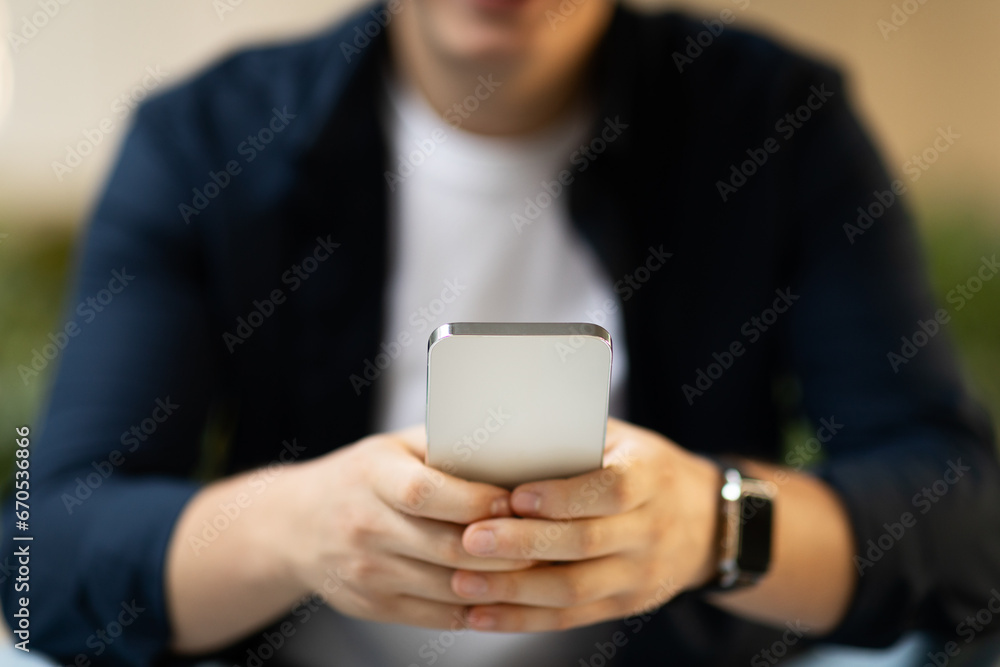 Young caucasian guy typing on smartphone focus on, enjoy chat in social networks with smartwatch Young caucasian guy typing on smartphone focus on, enjoy chat in social networks with smartwatch