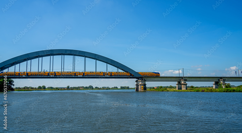 Train crossing the railbridge over the river Lek (Rhine) near Culemborg, Netherlands

