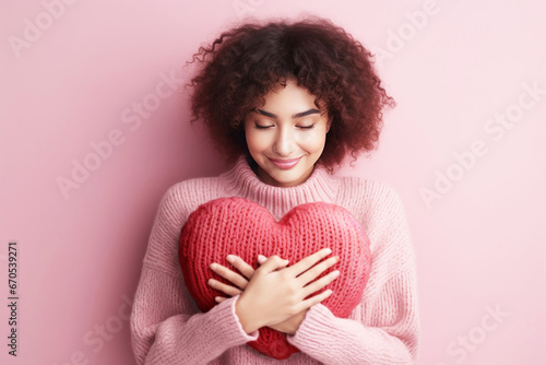 Young woman hugging a heart shaped for self love concept photo
