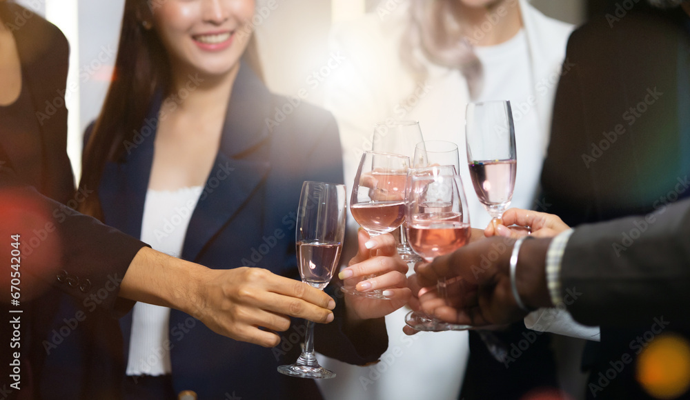 Closeup hand holding glassware. Business people celebrate making a toast on event party at office. Celebration Success Concept Closeup hand holding glassware. Business people celebrate making a toast on event party at office. Celebration Success Concept