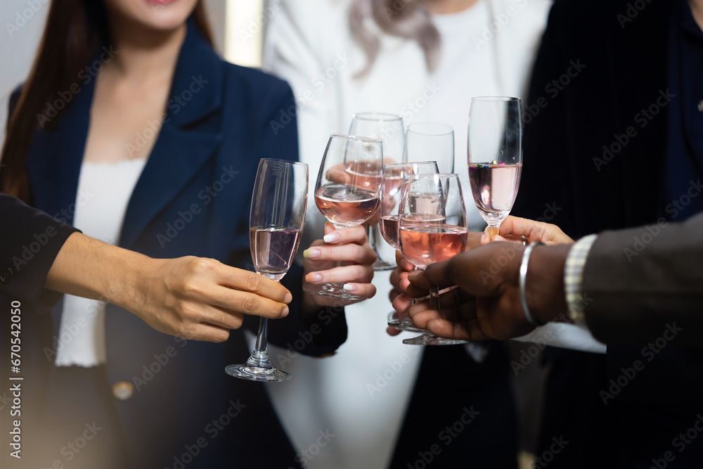 Closeup hand holding glassware. Business people celebrate making a toast on event party at office. Celebration Success Concept