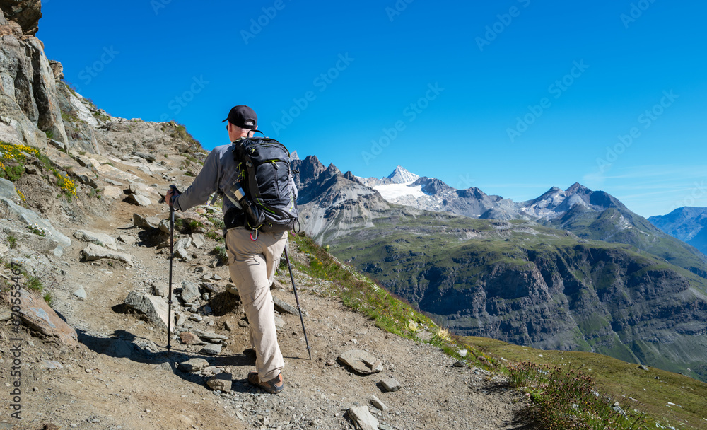 Switzerland travel - rear view of Senior man hiking the Swiss Alps enjoying the  mountain views