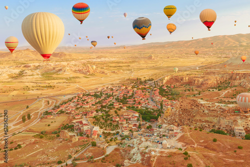 Balloons into Cappadocia's vast skyline. The brilliant hues of balloons capture dwindling daylight, casting a mesmerizing illumination on the surreal peaks below them in Goreme, Cappadocia in Turkey.
