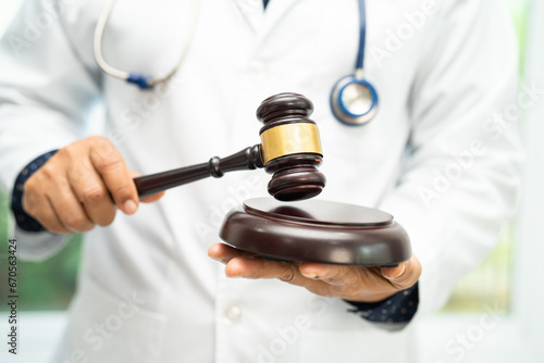 Doctor holding judge gavel, forensic medicine, medical law and crime justice concept. photo