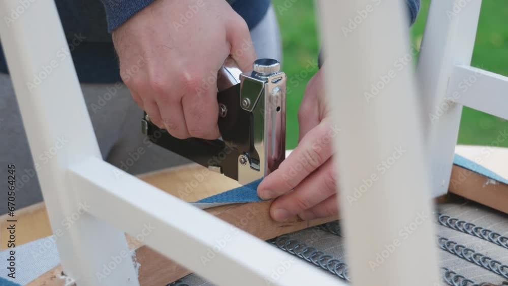 Production of upholstered furniture. A worker secures the