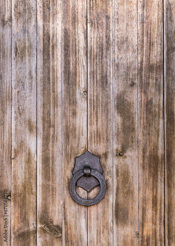 .Part of a large wooden door with an iron handle and ring. Spain