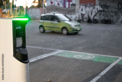 Charging station for electric cars with blurred background of car behind