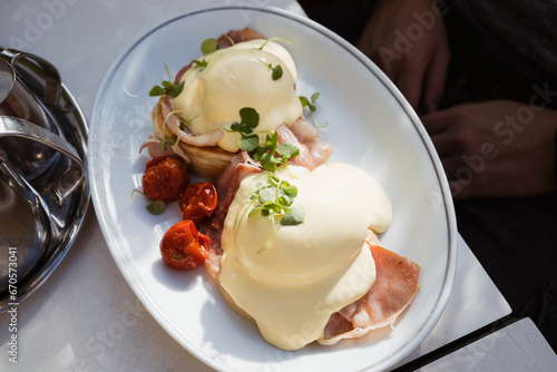 Eggs Benedict common American breakfast or brunch dish, consisting of two halves of an English muffin, each topped with Canadian bacon, a poached egg, and hollandaise sauce.