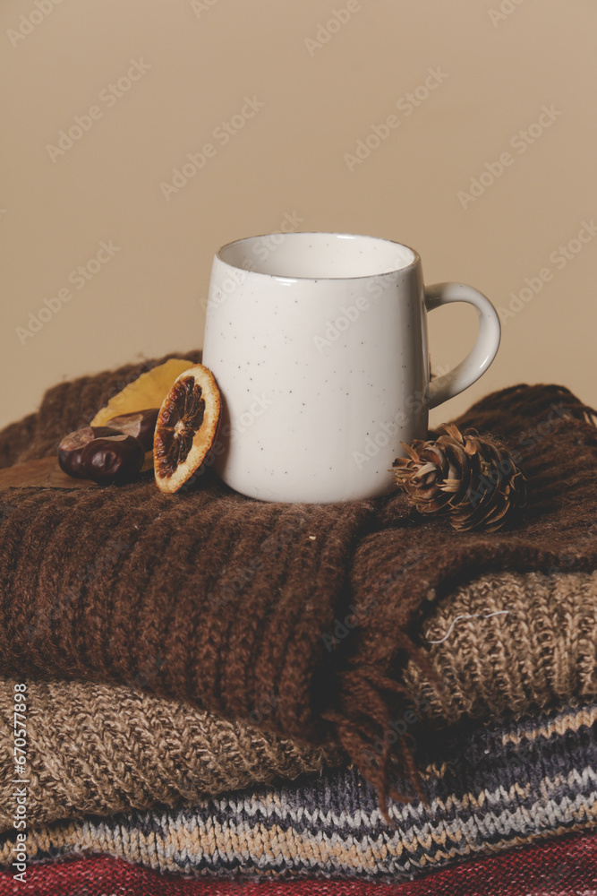 Cozy winter lifestyle concept. Cup of hot drink with warm knitted clothes.	