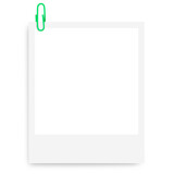 white Polaroid photo frame with a green paper clip on a blank background.