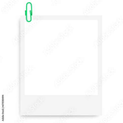 white Polaroid photo frame with a green paper clip on a blank background. photo