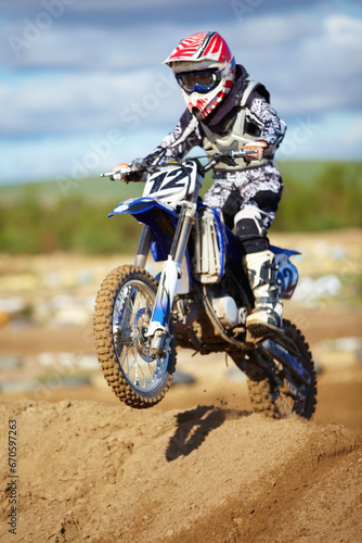 Fototapeta Naklejka Na Ścianę i Meble -  Man, motorcycle and bike hill jump as professional rider in action danger competition, fearless or race. Male person, transportation or fast speed dirt adventure or rally, challenge gear or driving